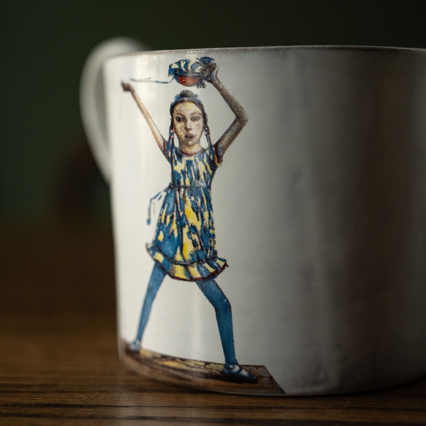 Close up of Carron Paris white mug with a colorful illustration of a dancing woman