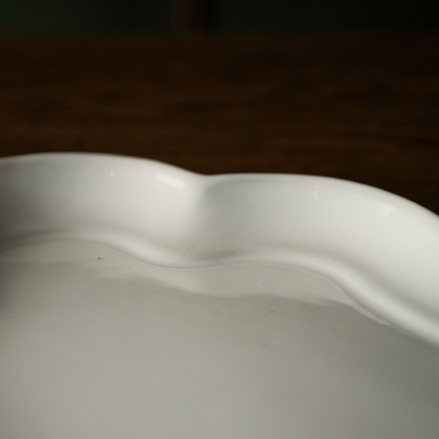 Close-up of a Carron Paris white ceramic platter with wavy edge