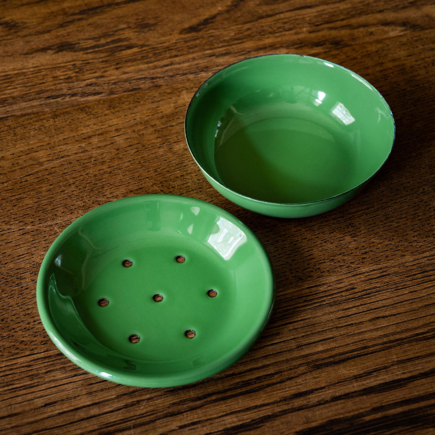 Two parts of the enamel green soap dish, bowl & top with drain holes