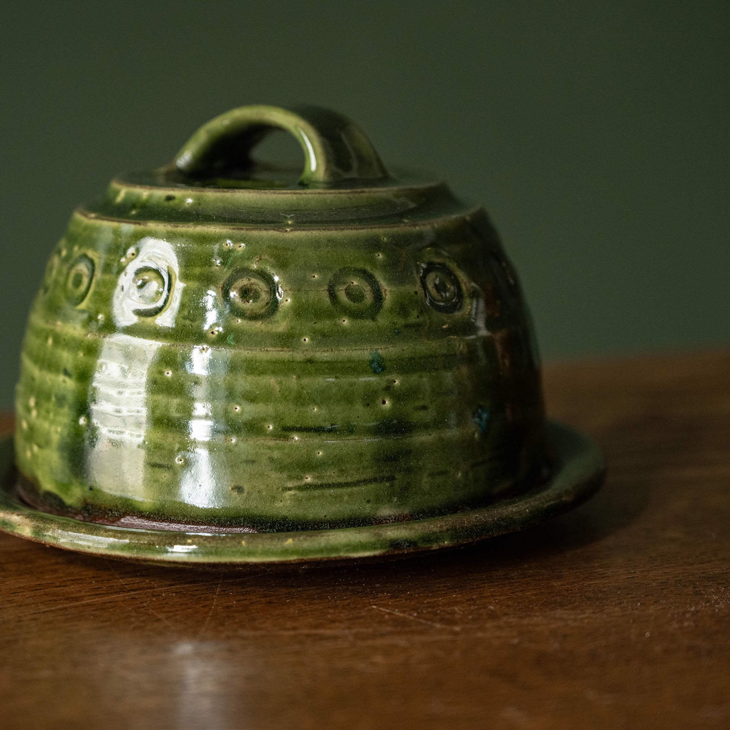 Close up of surface design of Joshua Williams green earthenware butter dish