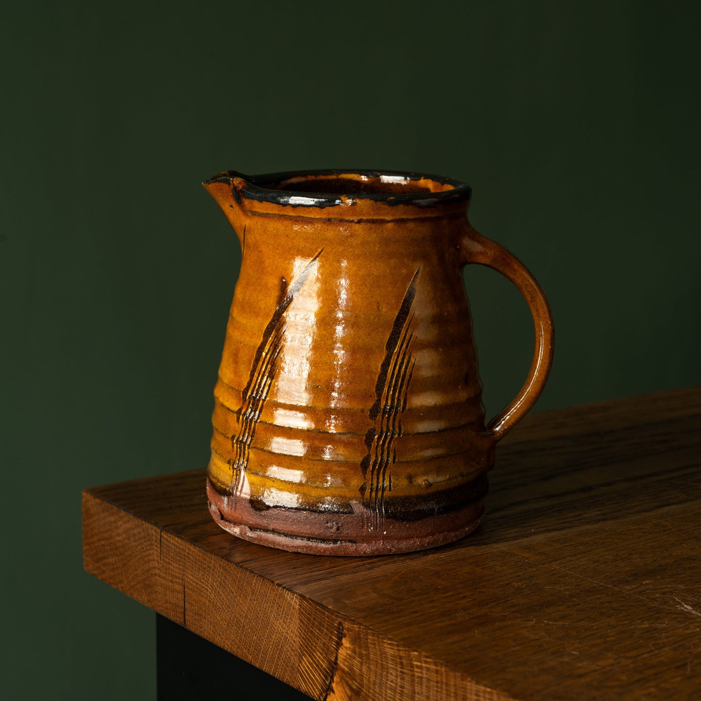Joshua Williams ochre earthenware jug on a wooden surface