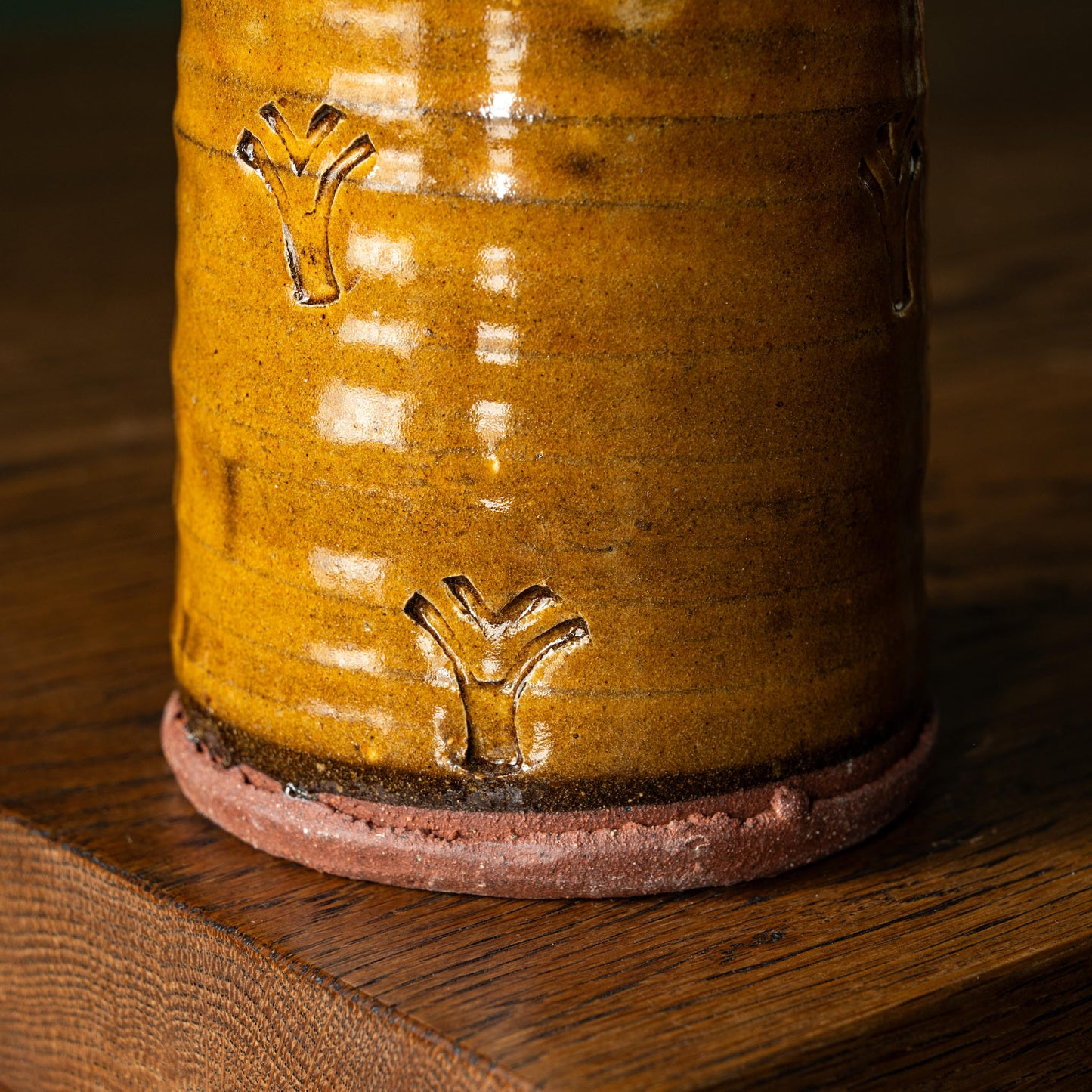Close-up of Joshua Williams ochre earthenware mug with embossed surface designs
