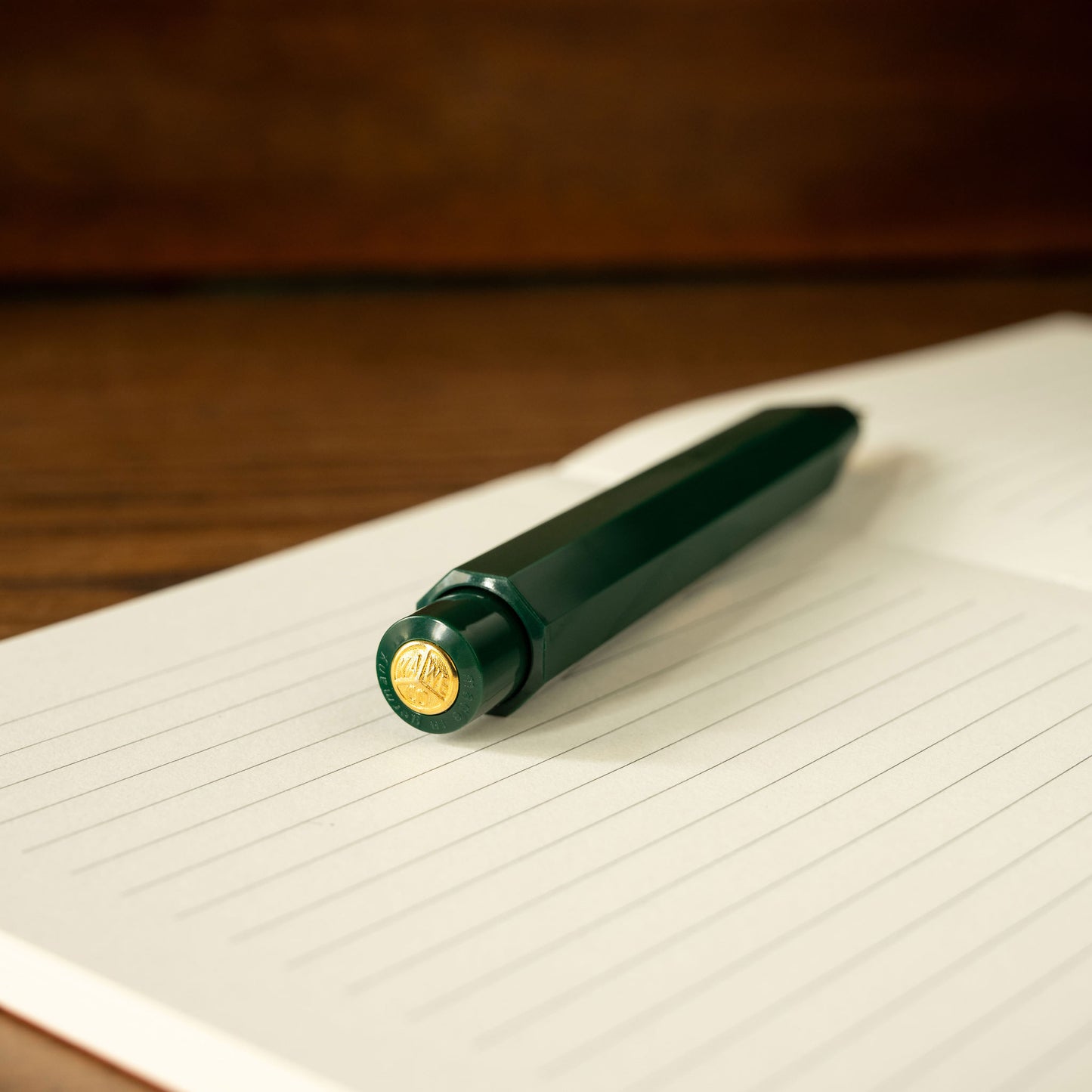 Kaweco Classic Sport green mechanical pencil push button barrel with gold accent on a lined notebook page