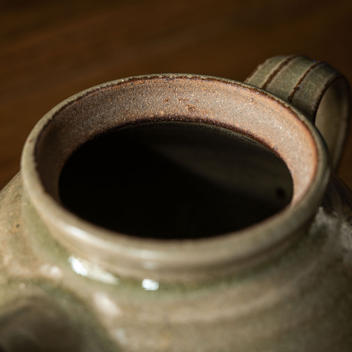Close-up of handmade Leach Pottery ceramic teapot showing the interior opening.