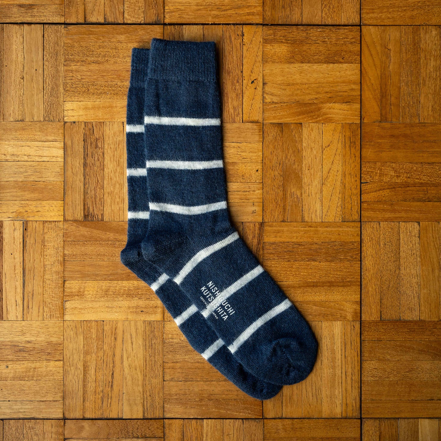 Nishiguchi Kutsushita Mohair Wool Border Socks in Navy with white horizontal stripes.