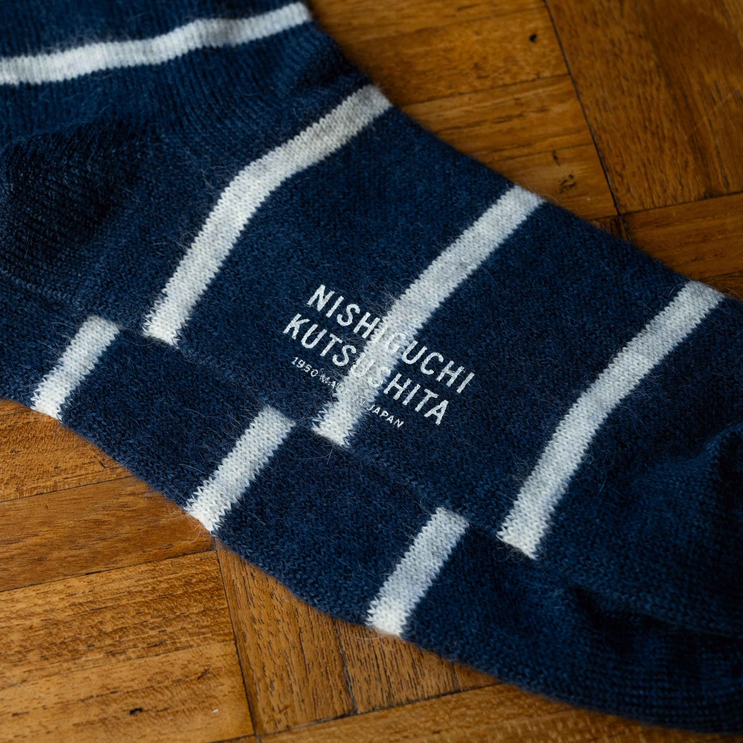 Nishiguchi Kutsushita Mohair Wool Border Socks in Navy with white horizontal stripes. Sole & logo detail.