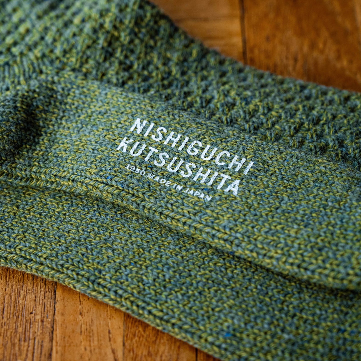 Sole with logo branding of Nishiguchi Kutsushita Moss Green Wool Boot Socks