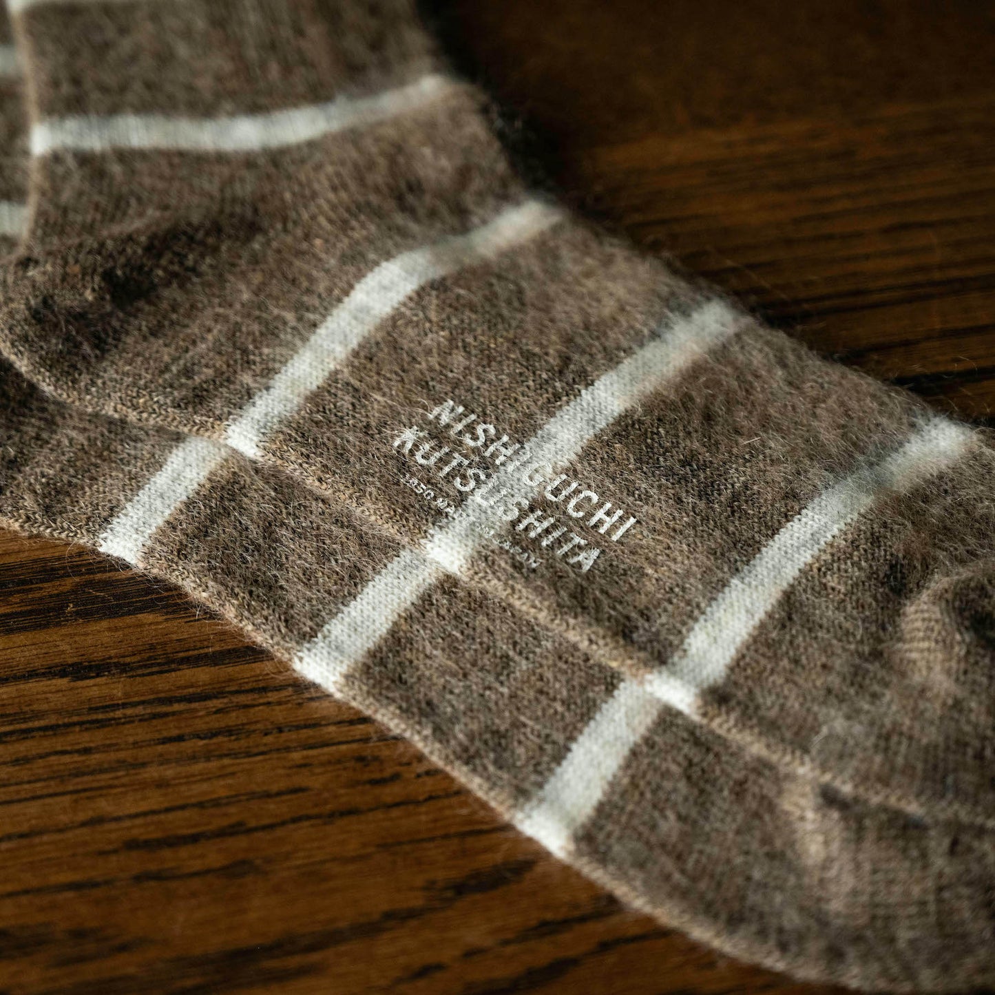 Beige Mohair & Wool socks with white stripes featuring the brand 'Nishiguchi Kutsushita' on the sole