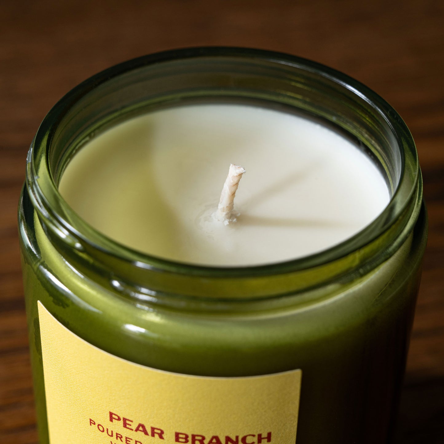 PF Candle Co "Pear Branch" scented candle wick in a green glass jar