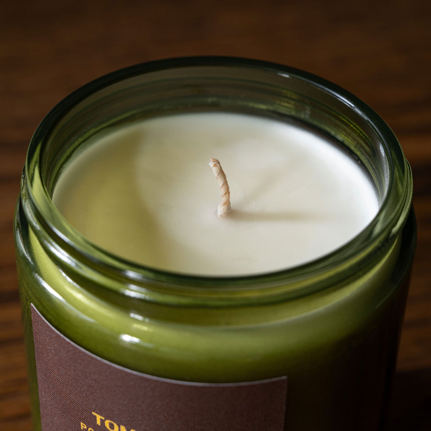 PF Candle Co Tomato Vines scented candle wick in a green glass jar.