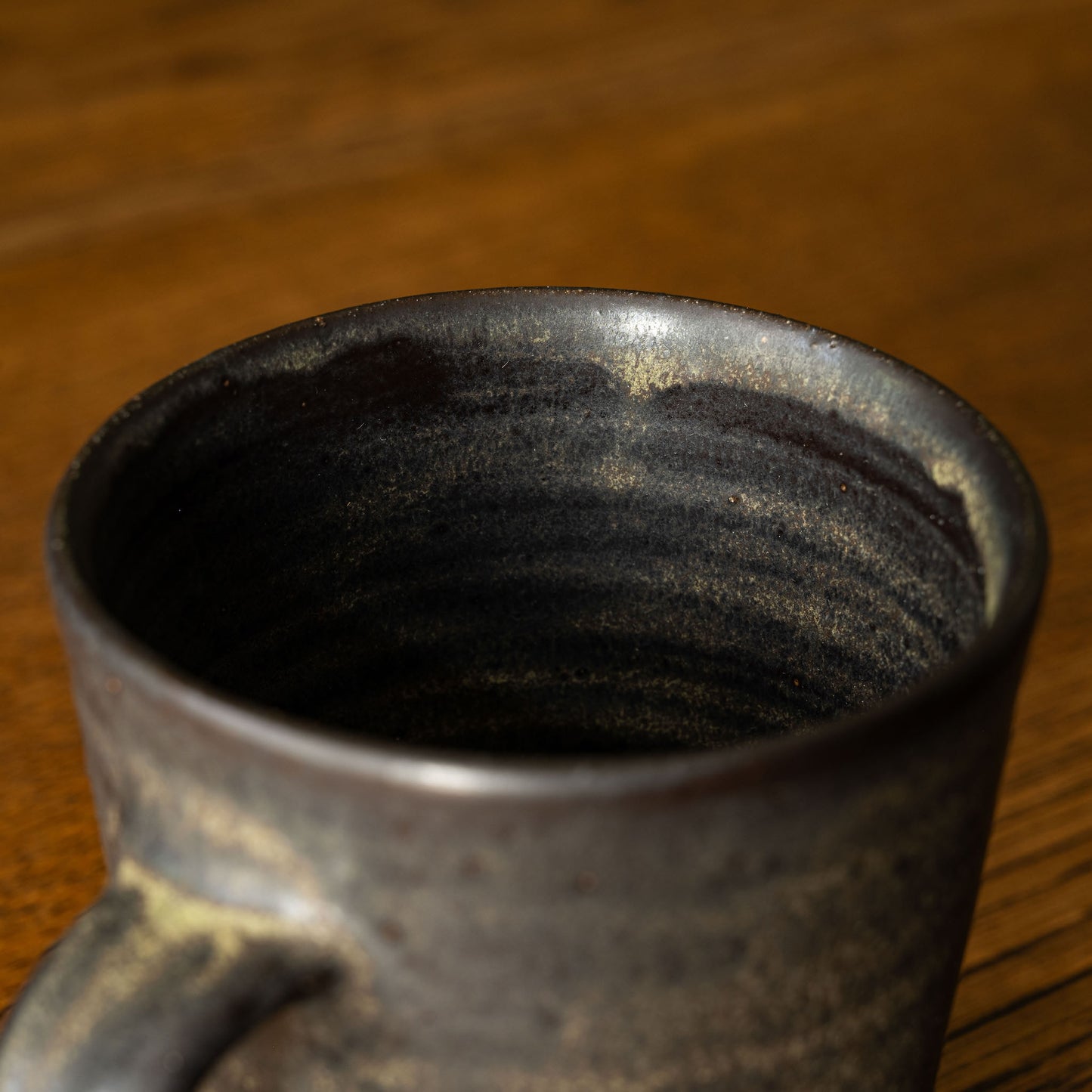 Inside view of Pottery West Stoneware Tapered Mug in Charcoal Glaze.