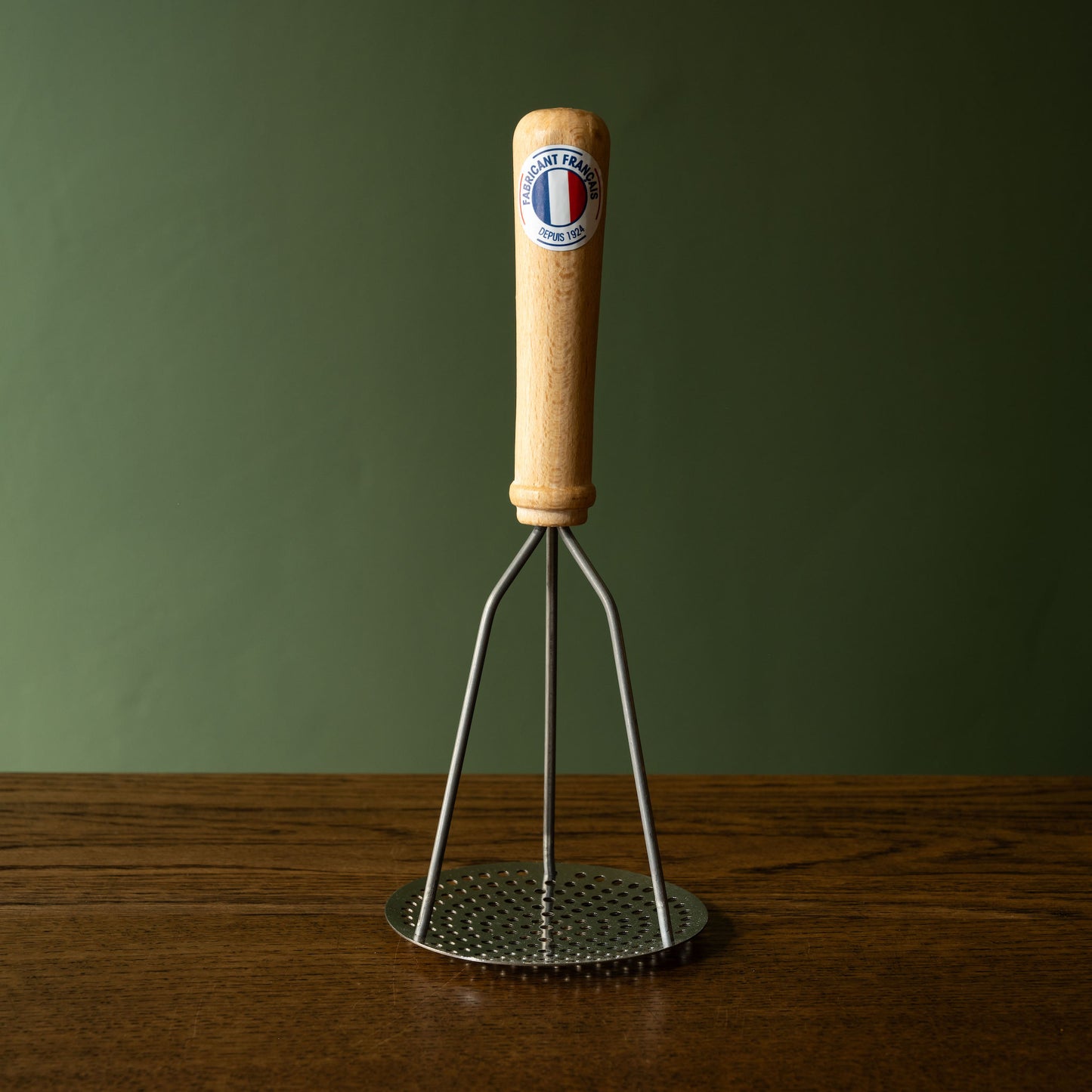 Potato masher with natural wood handle and steel masher