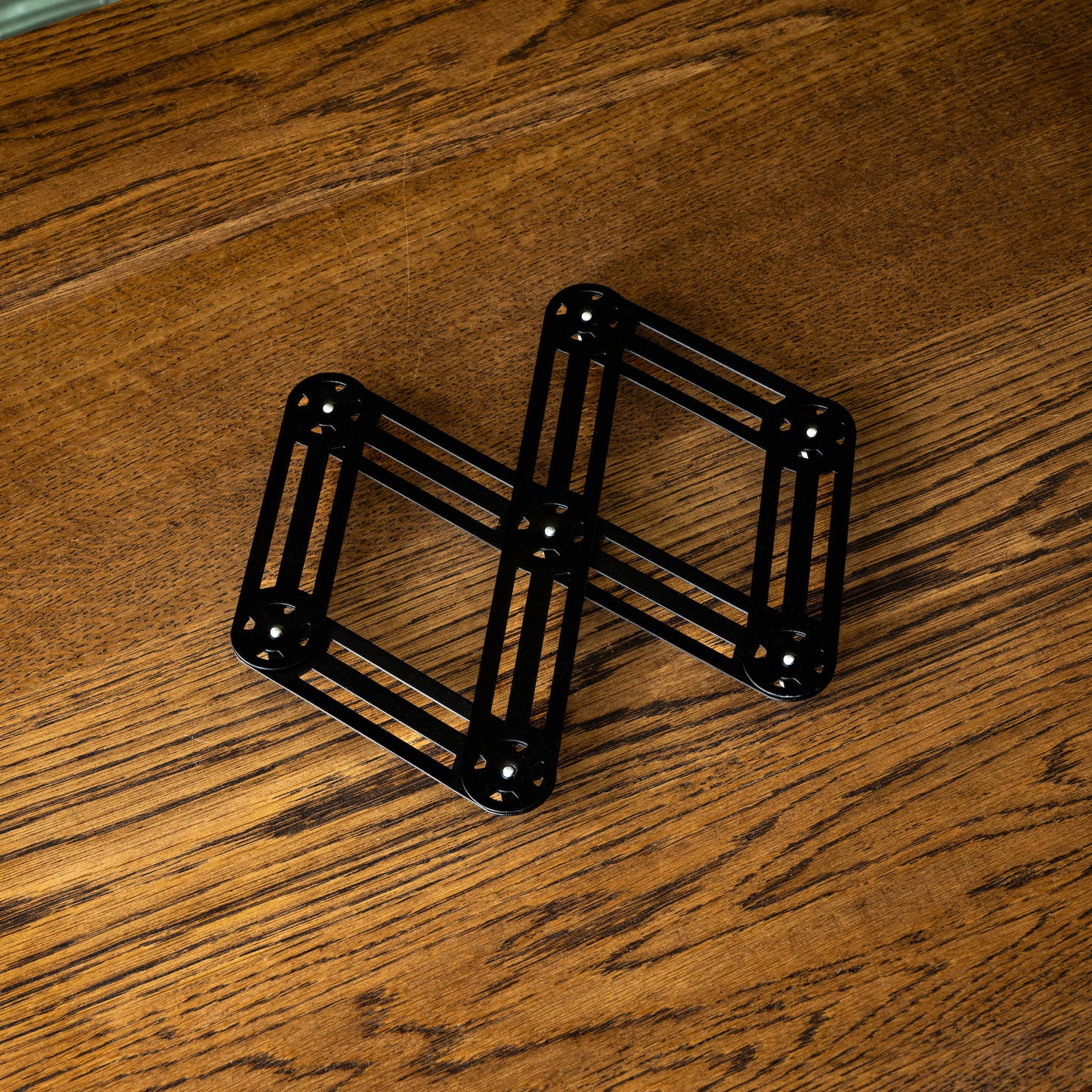 Stainless steel trivet in black, partially extended