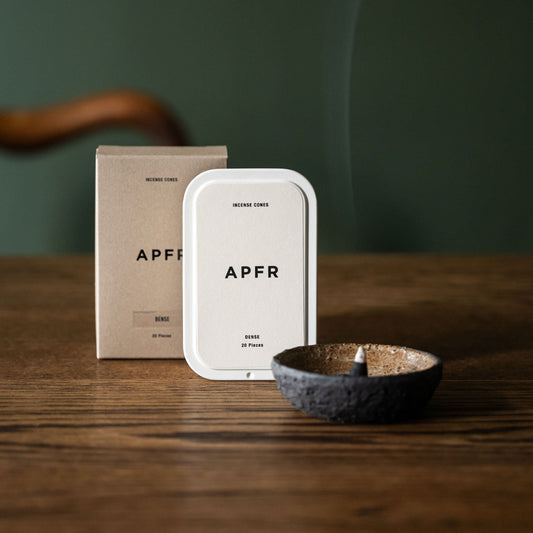 APFR Dense fragrance charcoal incense cone in a ceramic holder with packaging on a wooden surface 