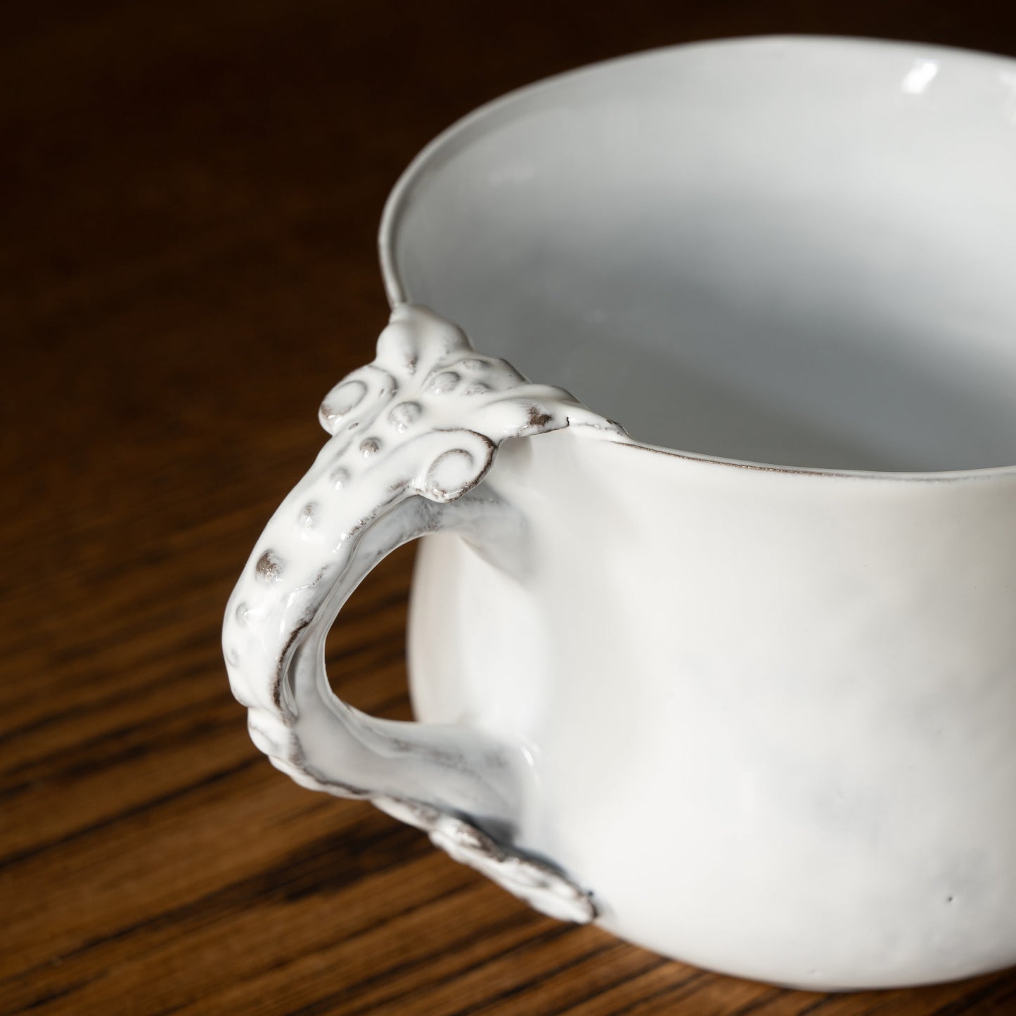 Carron Paris Marie-Antoinette white ceramic flared cup with decorative handle on a wooden surface