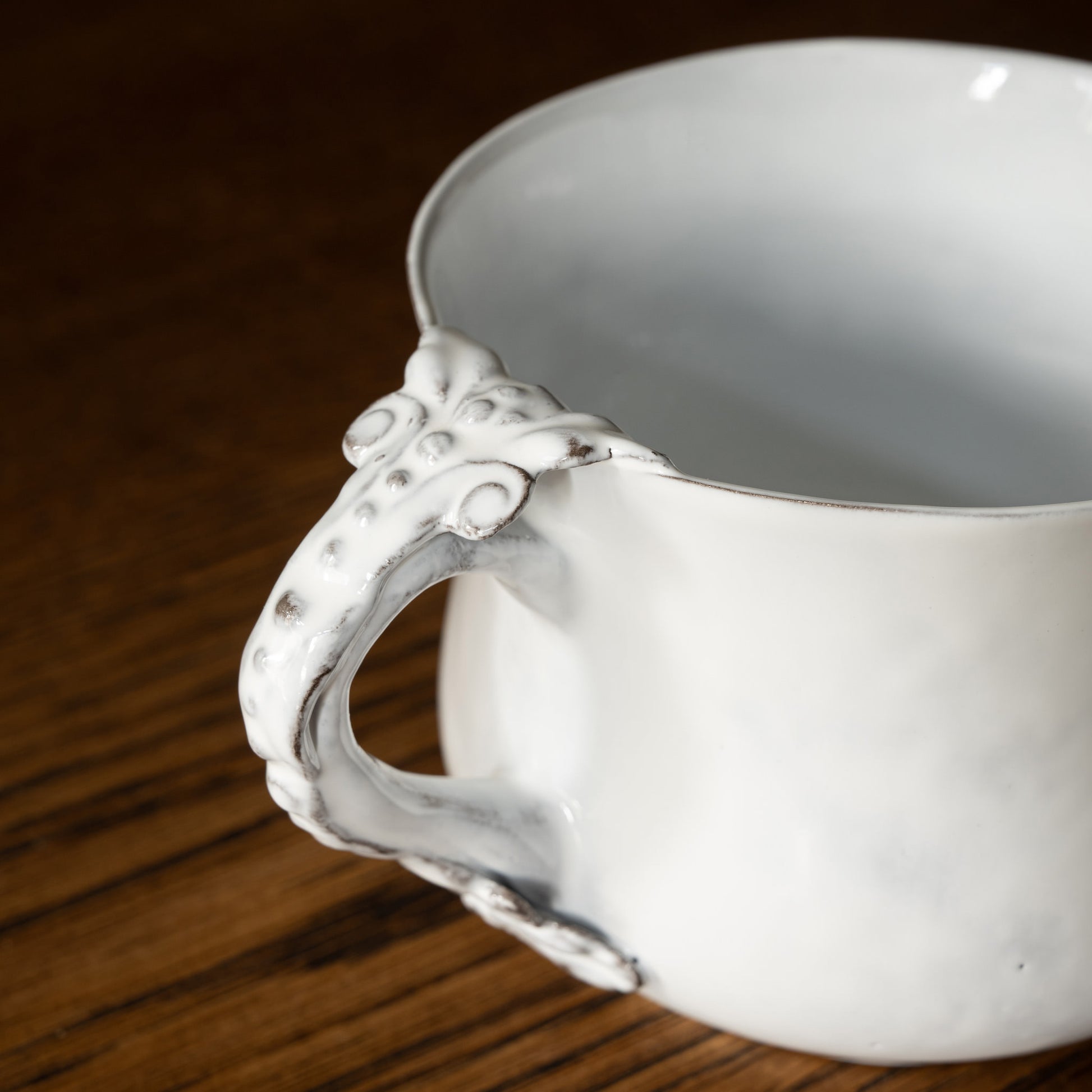 Carron Paris Marie-Antoinette white ceramic flared cup with decorative handle on a wooden surface