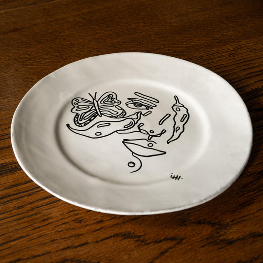 Carron Paris Piment et papillon large dessert plate with abstract face illustration. 