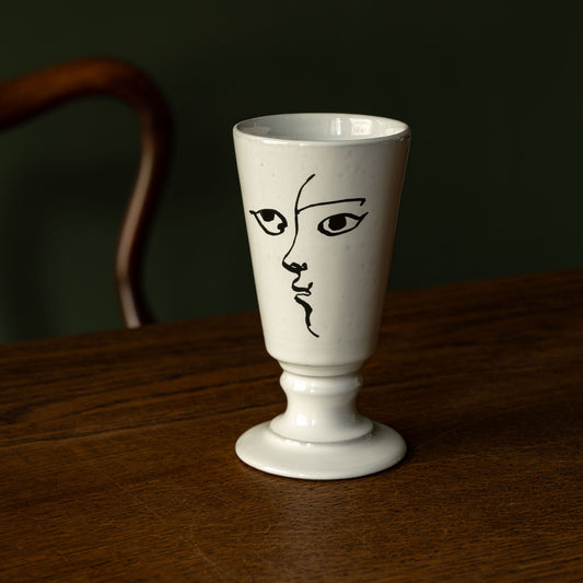 Carron Paris small white footed vase with an abstract illustrated face design 