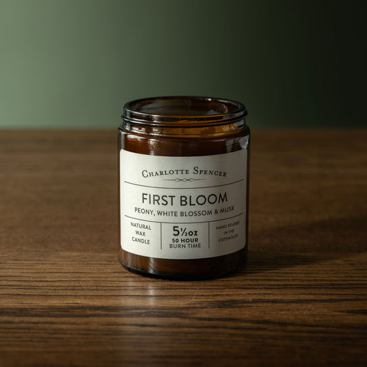 Charlotte Spencer 'First Bloom' candle a wooden surface with a green background