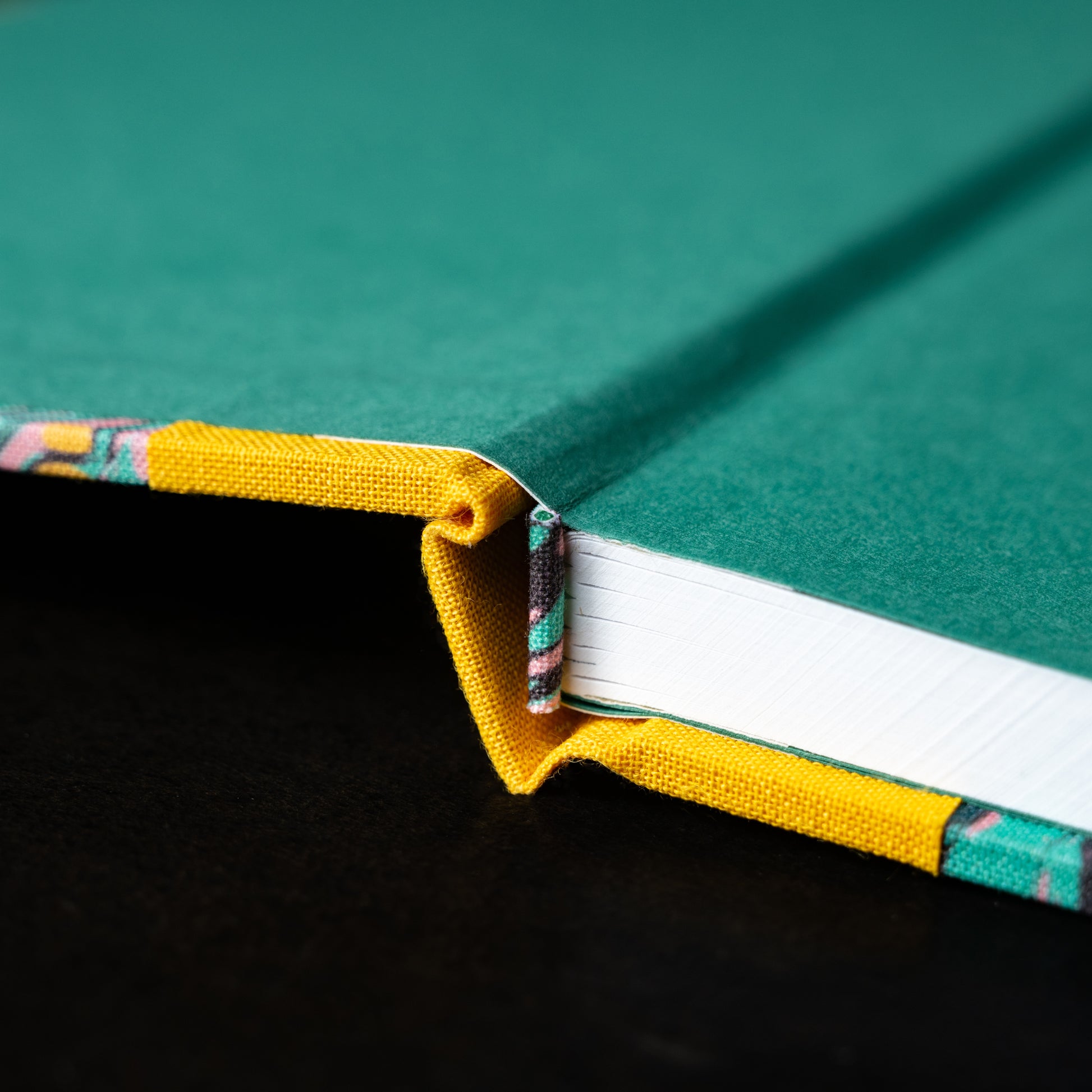 Close-up of Wainwright Bookbinding marled notebook spine and internal cover pages