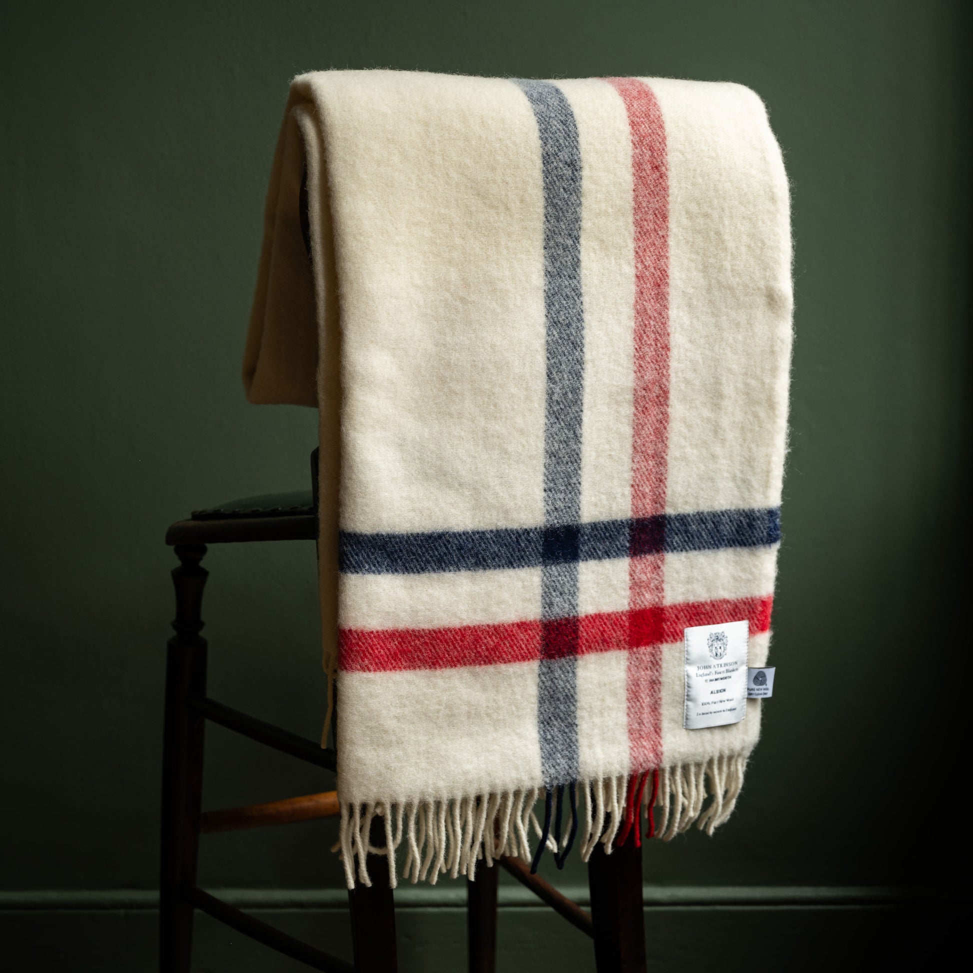 John Atkinson Albion Pure Wool Throw hanging over back of chair.