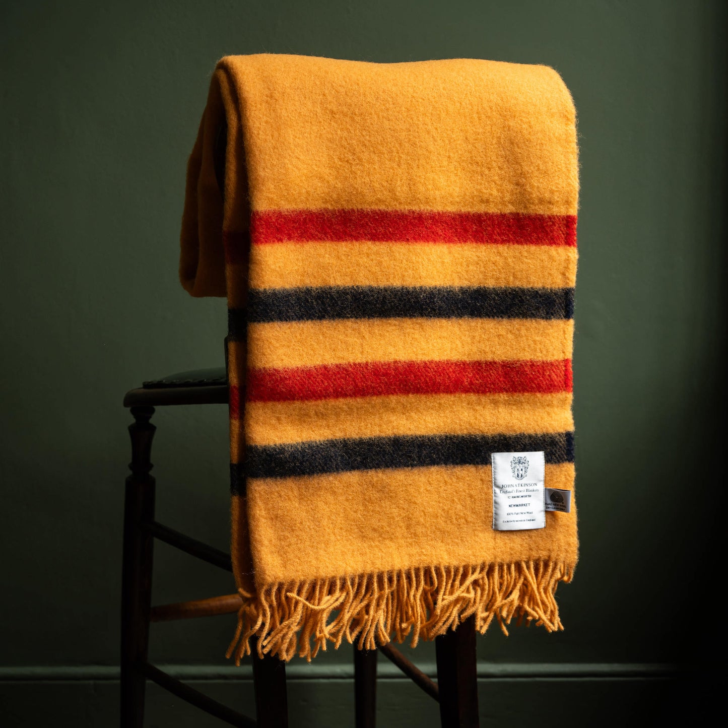 John Atkinson Newmarket Pure Wool Throw hanging over chair.