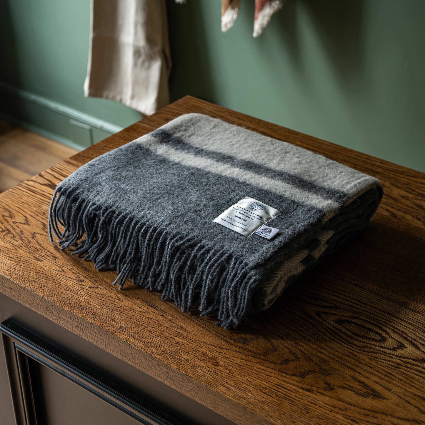 Folded John Atkinson Winston wool blanket in grey with off-white stripes 