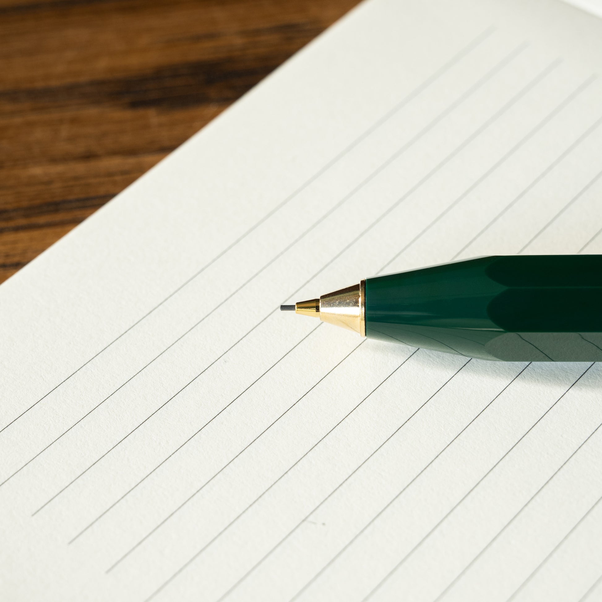 Kaweco Classic Sport green mechanical pencil showing 0.7mm lead on a lined notebook page 