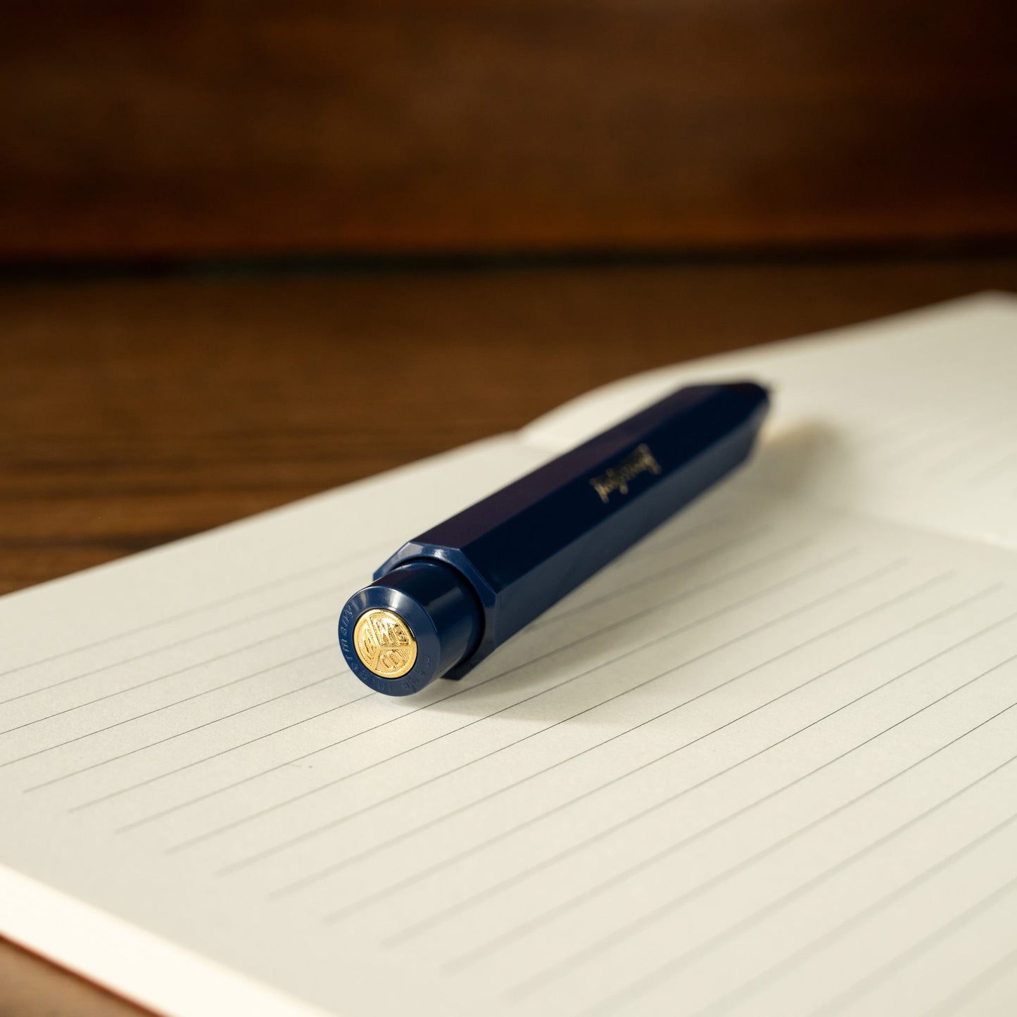 Kaweco Classic Sport blue mechanical pencil push button barrel with gold accent on a lined notebook page