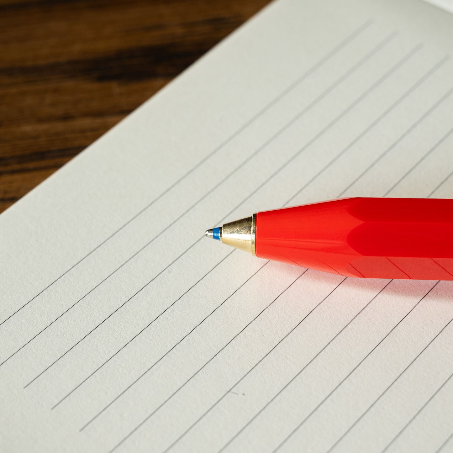 Kaweco Classic Sport red ballpoint pen nib on a lined notebook page 