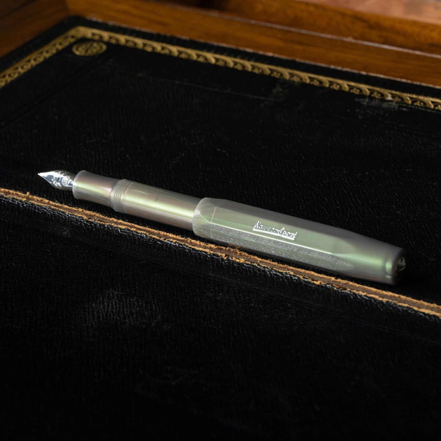Kaweco LUNAR Sport Shadow Green fountain pen on a black leather writing desk surface