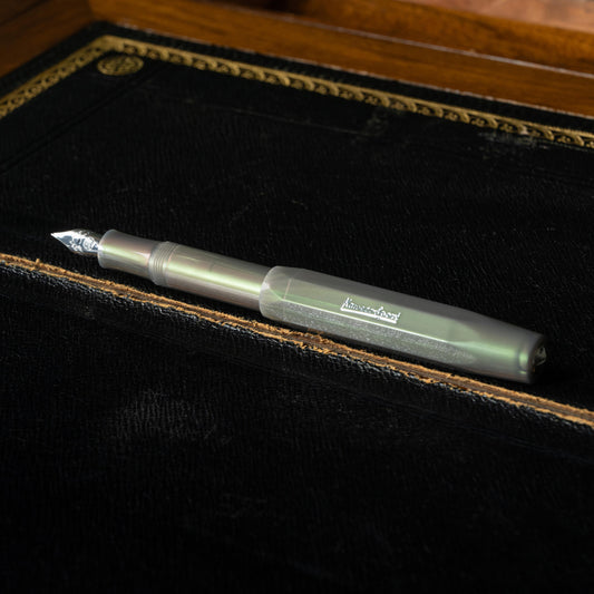 Kaweco LUNAR Sport Shadow Green fountain pen on a black leather writing desk surface