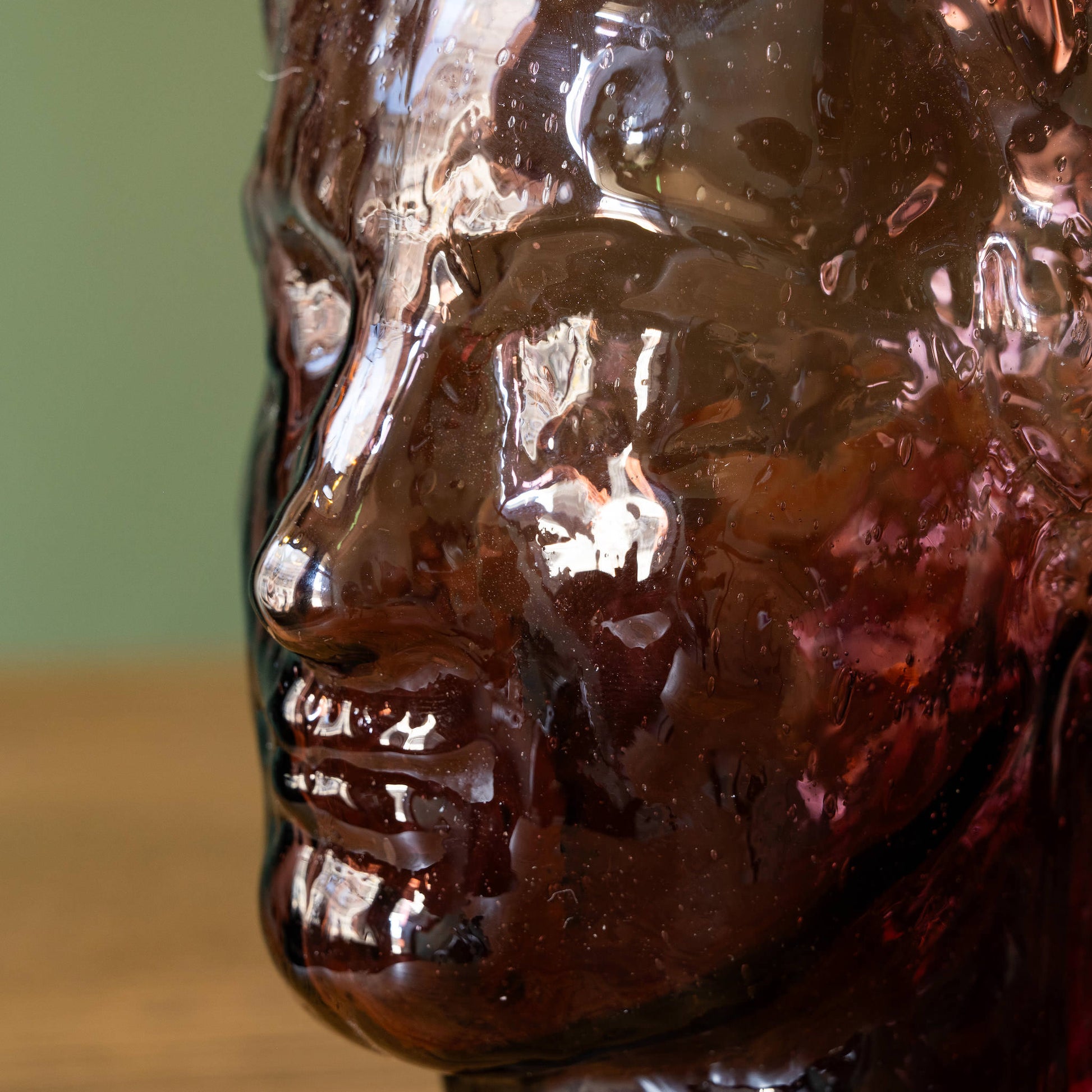 Face design close up of La Soufflerie Roma Vase. Mouth blown recycled glass in framboise colour.