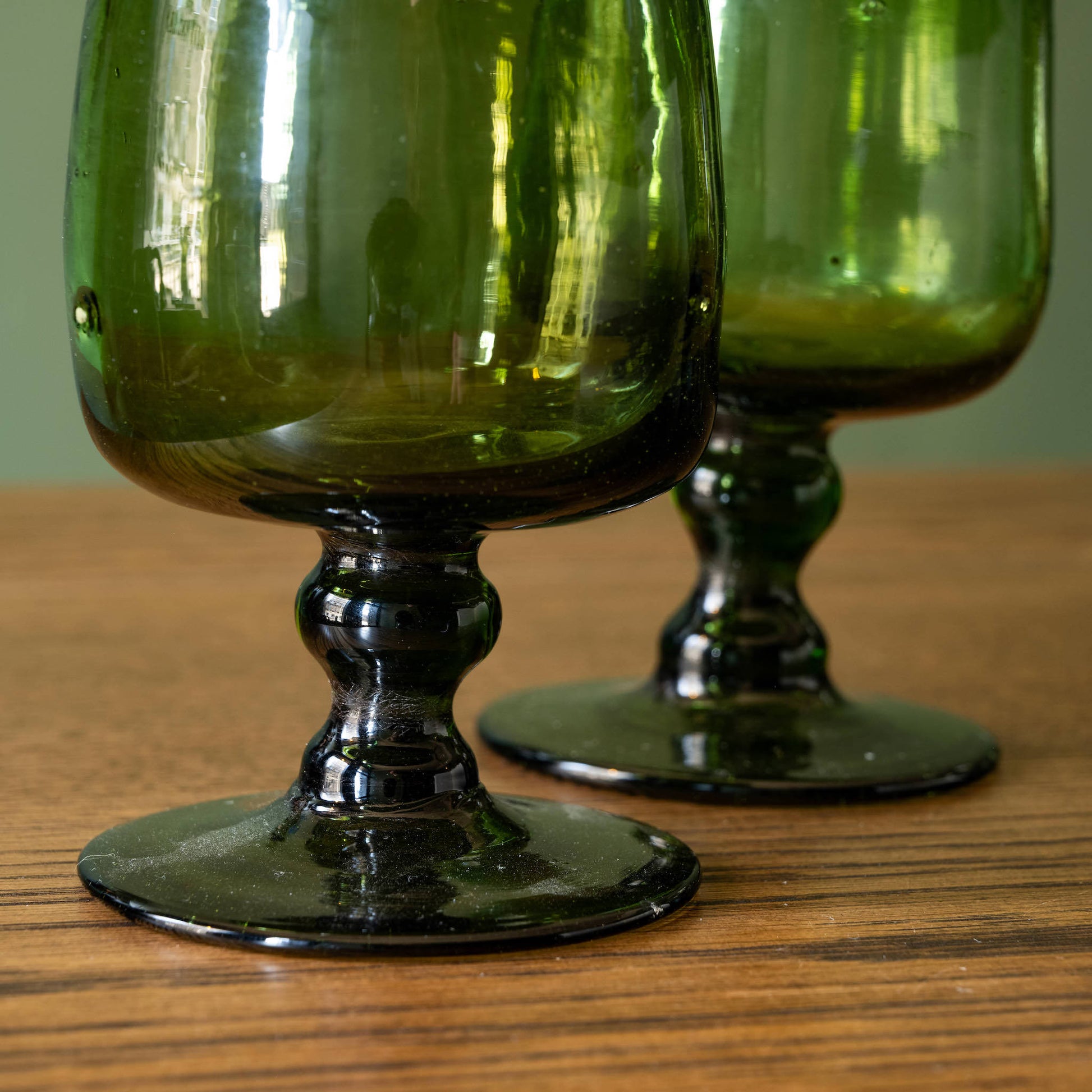 Stems & base of pair of La Soufflerie Vert Fumé Red Wine Glasses. Mouth blown from recycled glass in smoked green. 