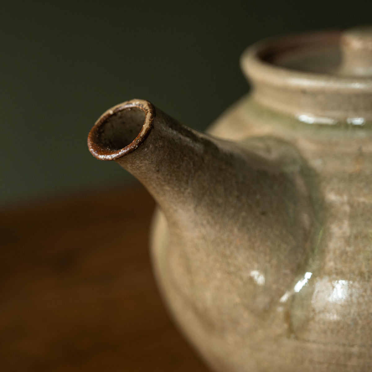 Close-up of handmade Leach Pottery ceramic teapot with an Ash green glazed finish, focusing on the spout.