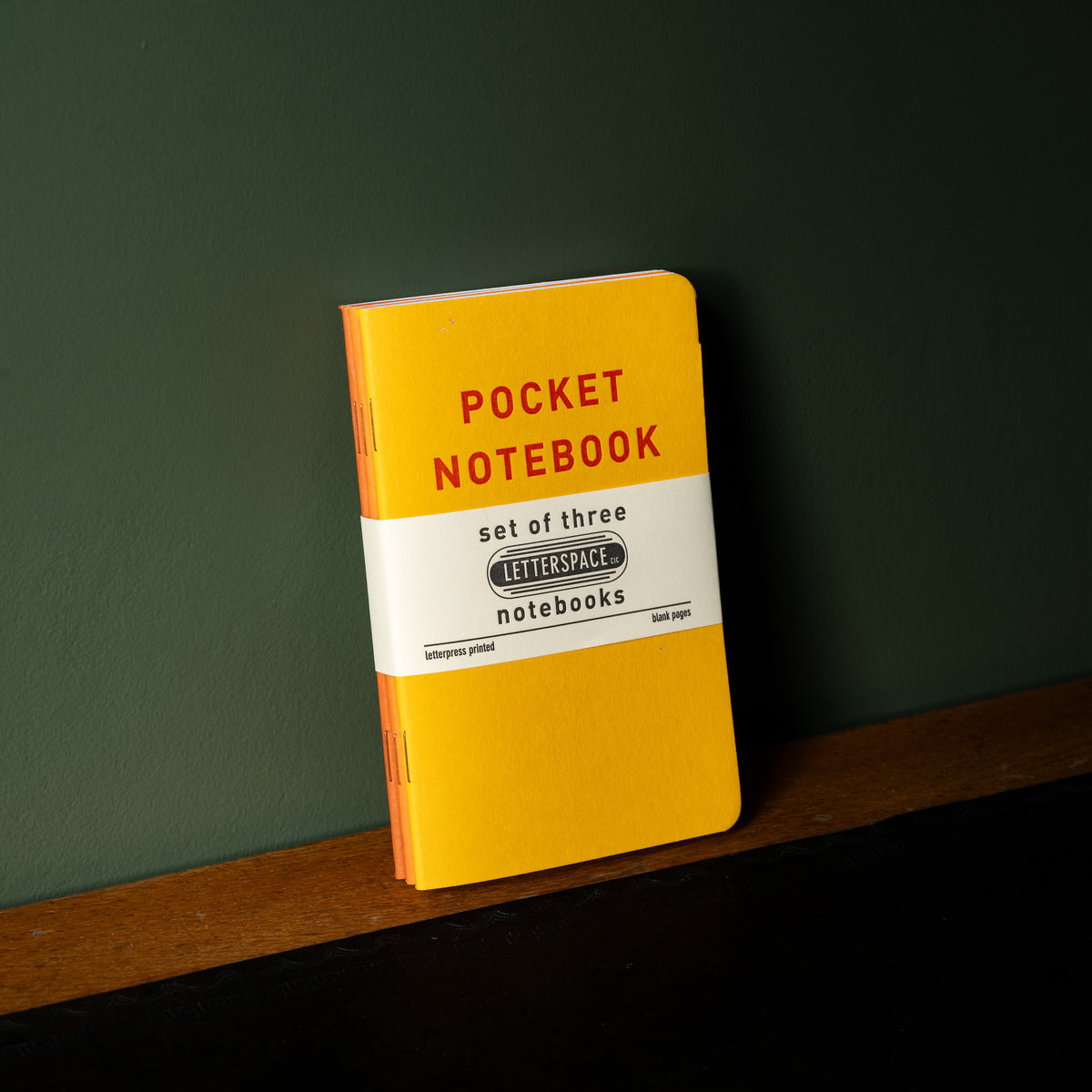 Set of 3 Letterpress pocket notebooks with individual covers in tones of yellow with red text 