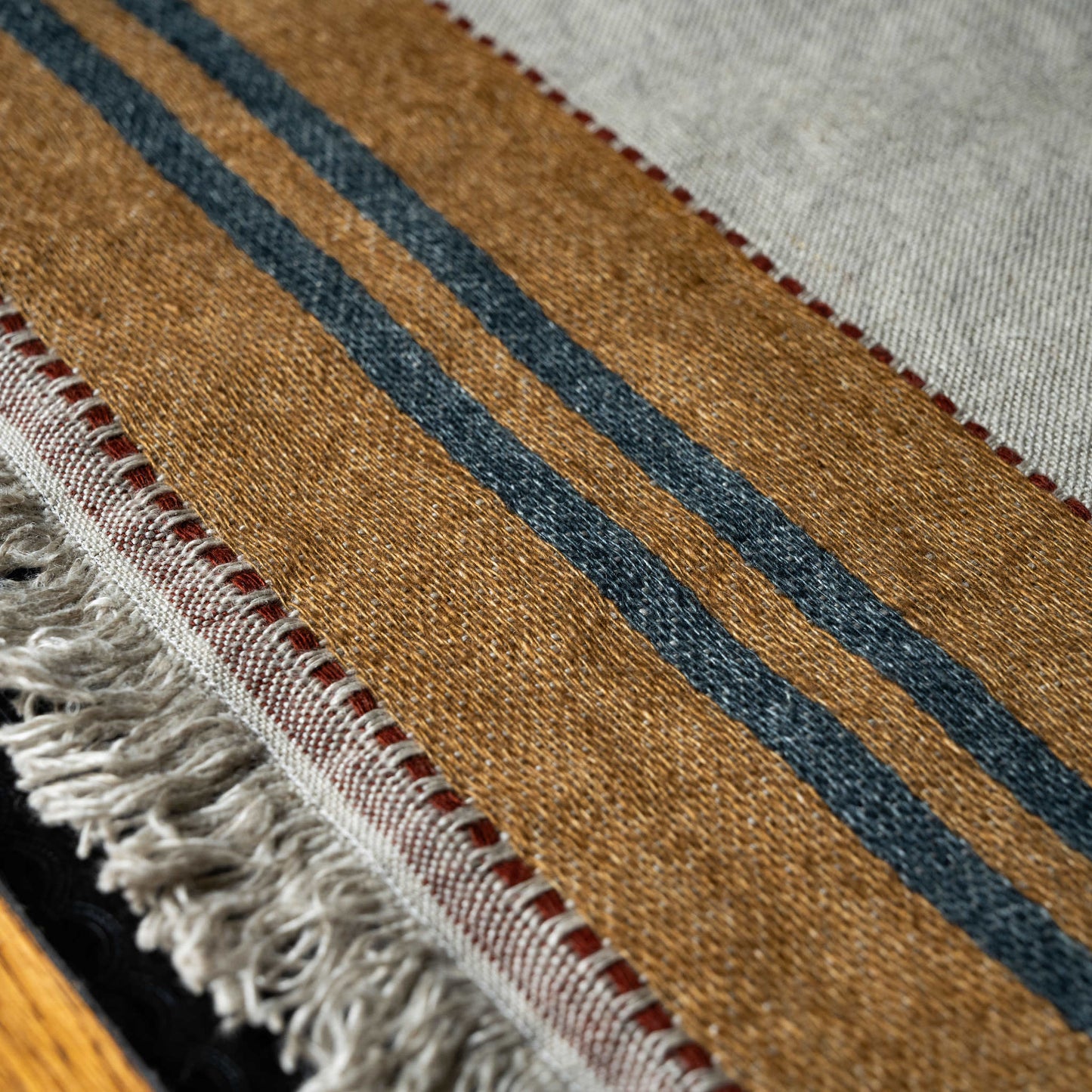 Close-up of striped Libeco Hillside linen napkin with brown, blue, and beige colours.