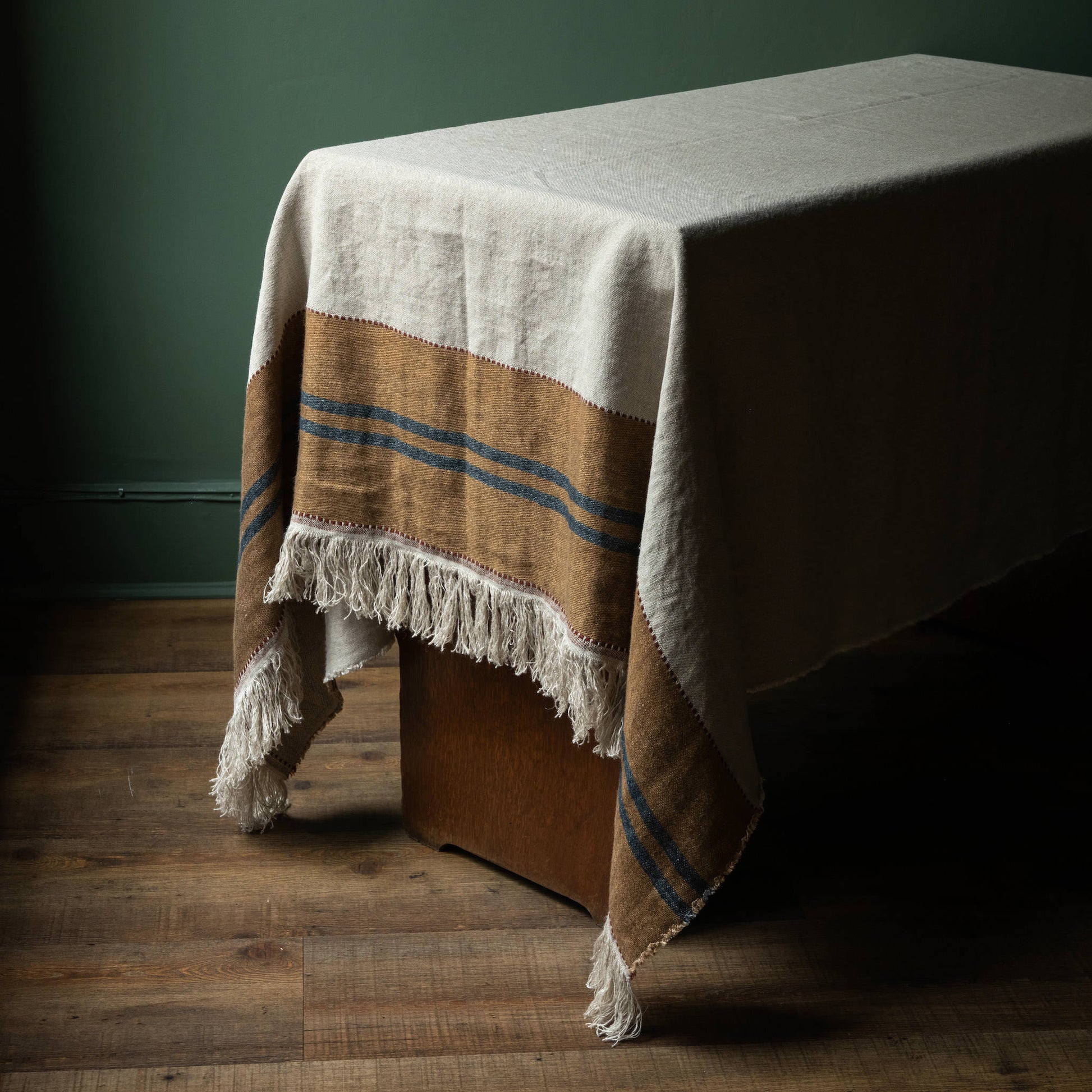 Libeco Belgian Linen Hillside Table Throw. Natural Flax colour with old & leather coloured band and dark blue stripes and fringed edge. 