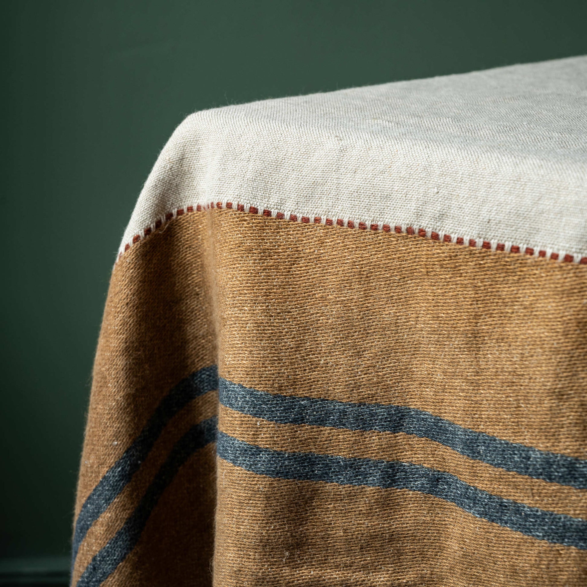 Close-up of Libeco Hillside table throw with brown band with dark blue stripes 