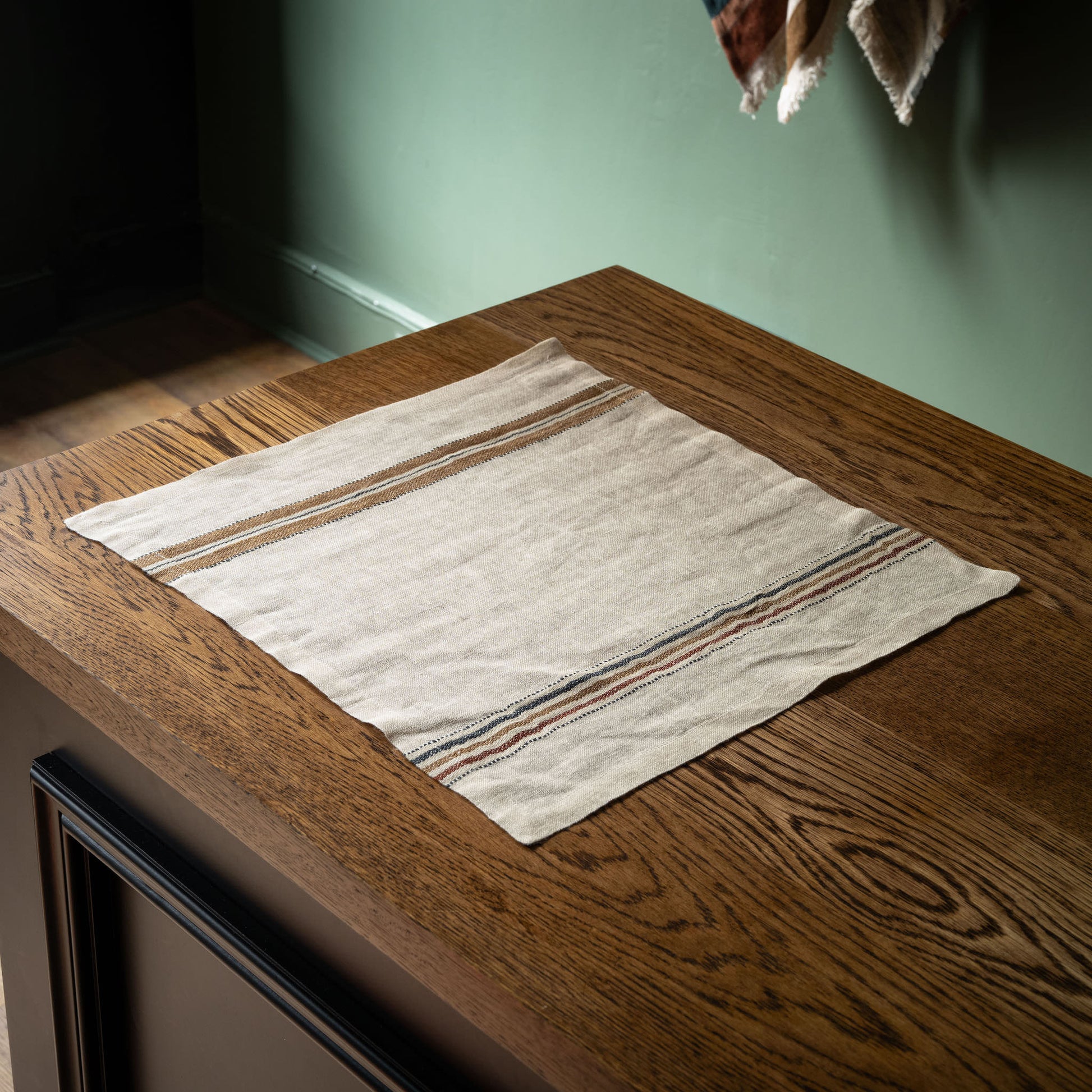 Libeco Belgian Linen Perry striped napkin on a wooden surface 