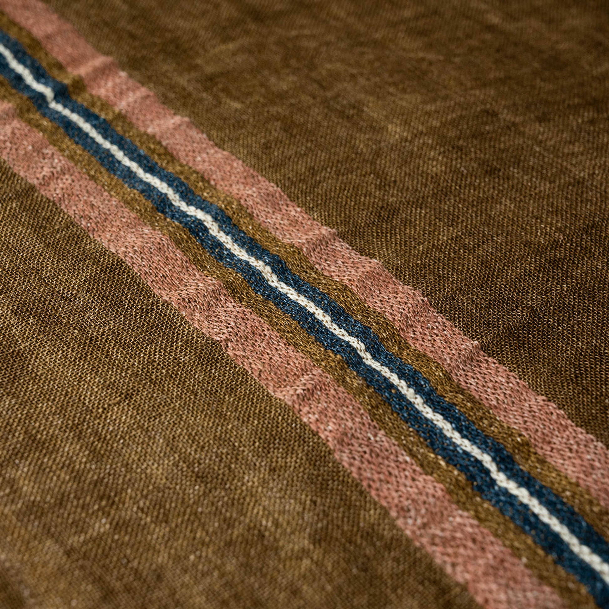 Close-up of brown Libeco Virginia napkin with pink natural white & blue stripes