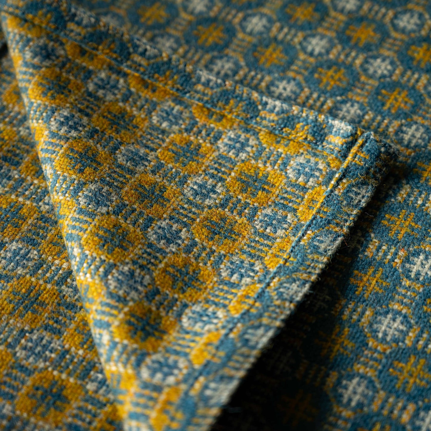 Close-up of both sides of Melin Tregwynt Teils Welsh Blanket with a blue and yellow geometric design