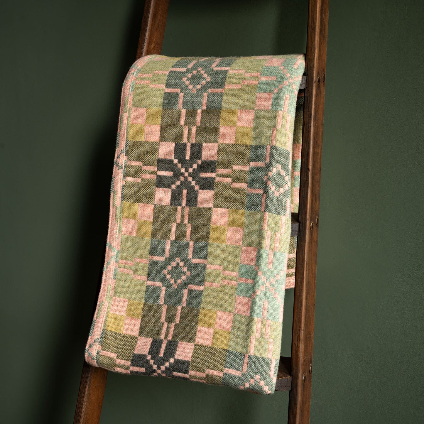 Reverse side of Melin Tregwnt Welsh wool blanket. Vintage Star design in hues of pink and green 