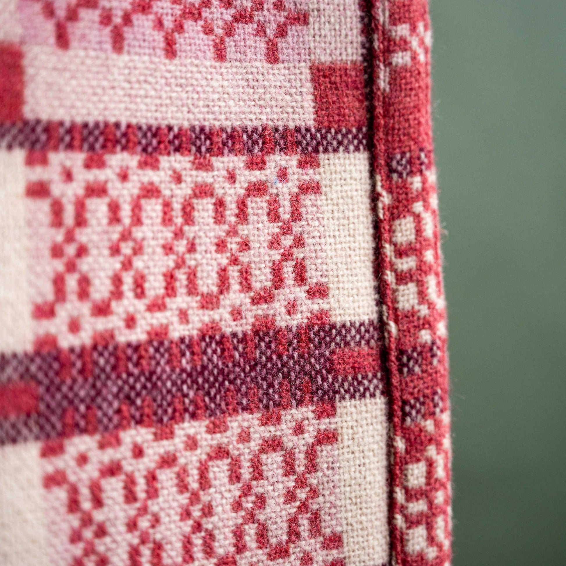 Close up of reverse side Melin Tregwynt Welsh Blanket, Knot Garden design in Mafon colour. 