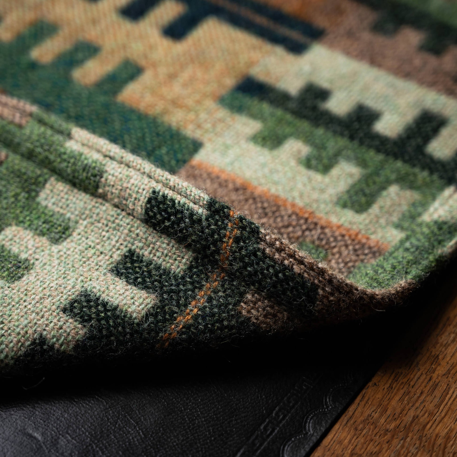 Reverse side and stitched hem detail of Melin Tregwynt Welsh blanket in Forest design