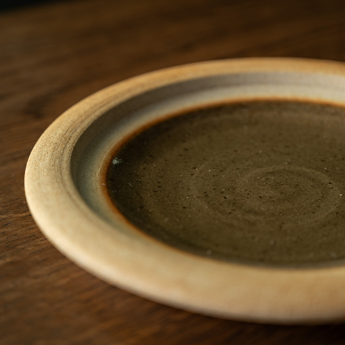 A close-up of Muchelney Pottery handmade ceramic plate from the two part butter dish set.