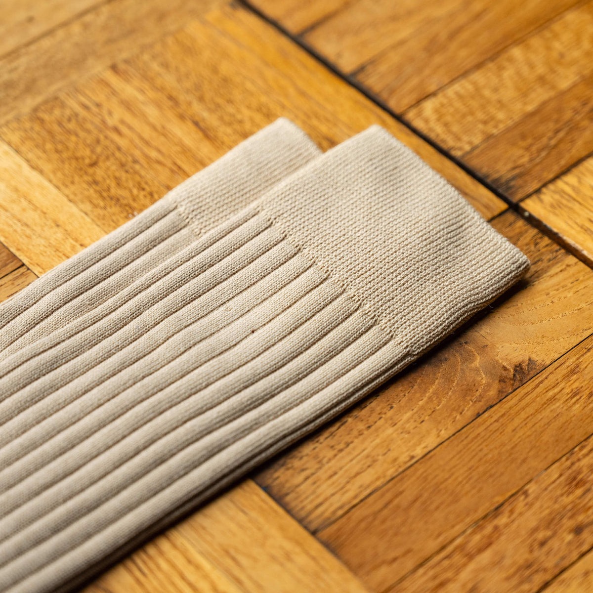 A close-up of Nishiguchi Kutsushita  Silk and Cotton ribbed sock in an oatmeal colour, showing the cuff detail.