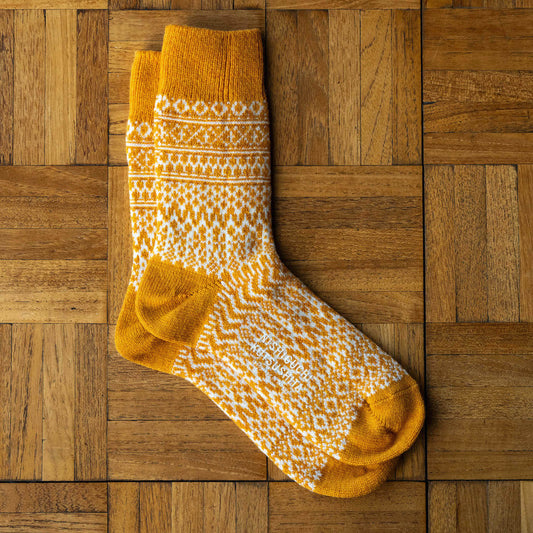 Nishiguchi Kutsushita wool jacquard socks in lantern orange with white geometric design