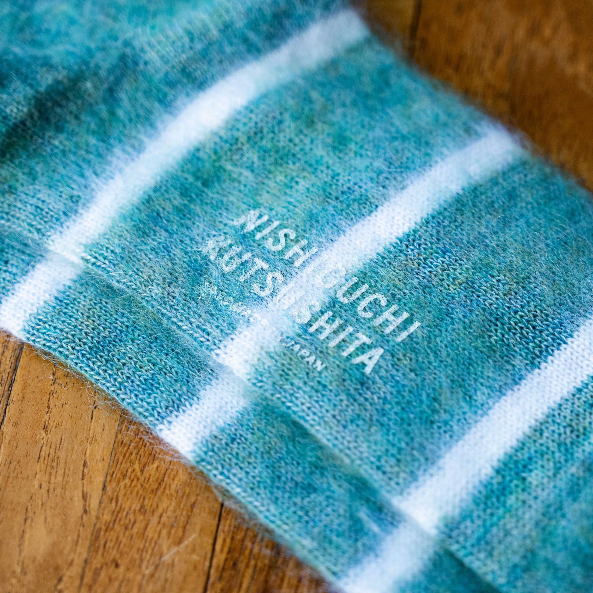 Turquoise Blue with white striped socks with 'Nishiguchi Kutsushita' branding on sole
