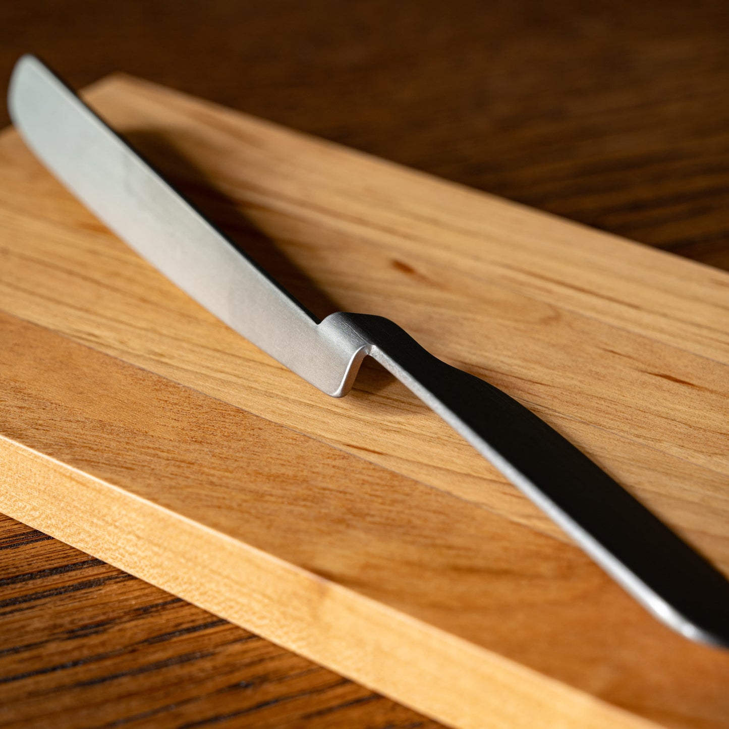 A close-up of the OKU folded stainless steel butter knife.